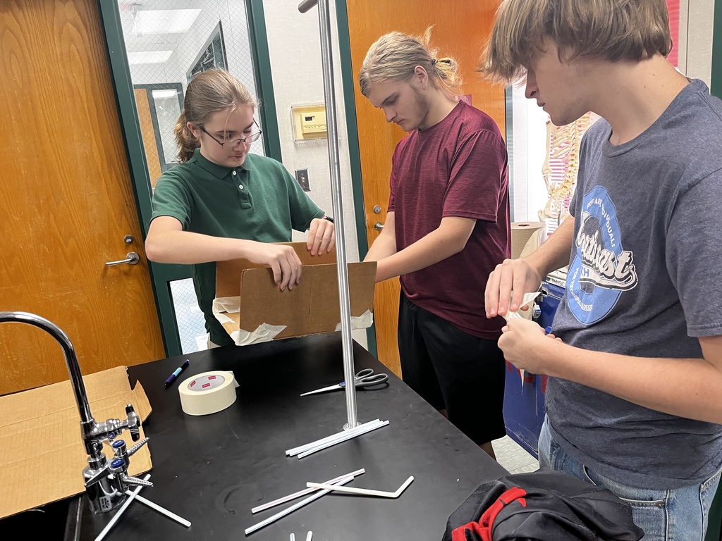 high school stem kids building their cardboard bridge